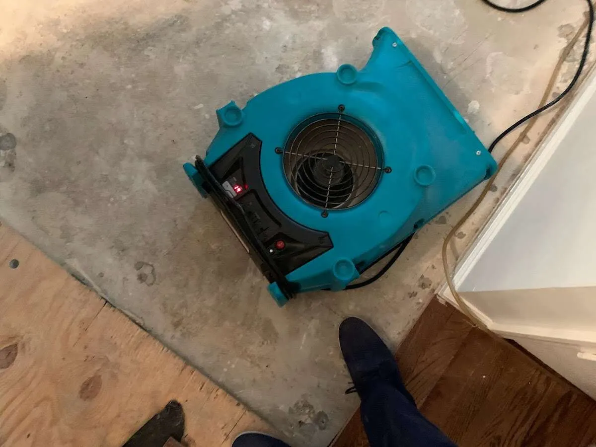 Air mover drying subfloor during Commercial Water Damage Restoration in Hollis